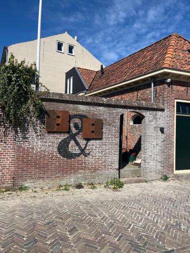 a brick building with a painting of an anarchy at Herberg Ferwert De Kr oon van Marijn in Ferwerd
