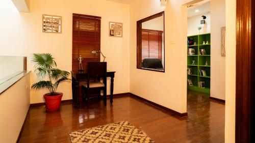 a hallway with a desk and a chair and a table at Luho 6 off Sarjapur Road in Bengaluru