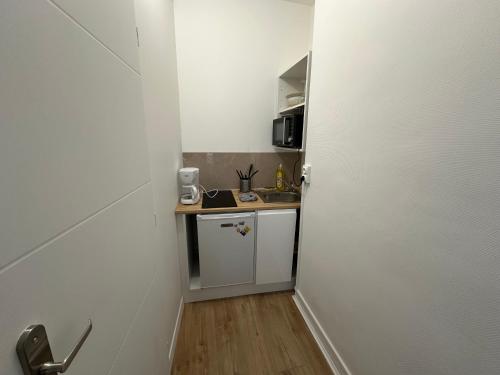 une petite cuisine avec un évier et un comptoir dans l'établissement Pause Douceur en Ville - 292, à Rouen