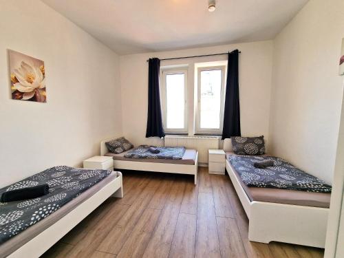 a room with three beds and a window at Worker's Apartment in Leverkusen L1-4 in Leverkusen