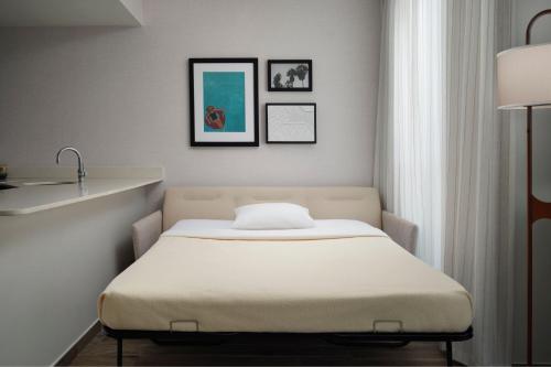 a bed in a room with two pictures on the wall at Residence Inn by Marriott Miami Beach Surfside in Miami Beach