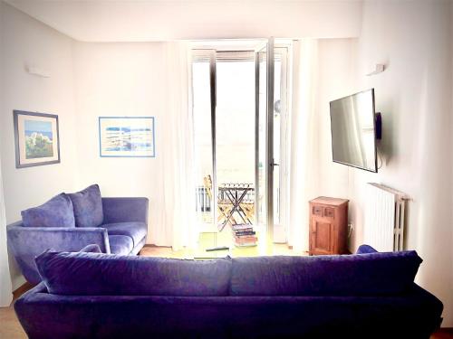 a living room with a purple couch and a window at Don Nicola Tourist Location in Polignano a Mare