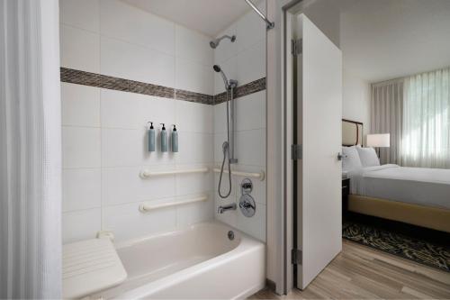 a bathroom with a tub and a shower in a room at Residence Inn by Marriott Miami Beach Surfside in Miami Beach