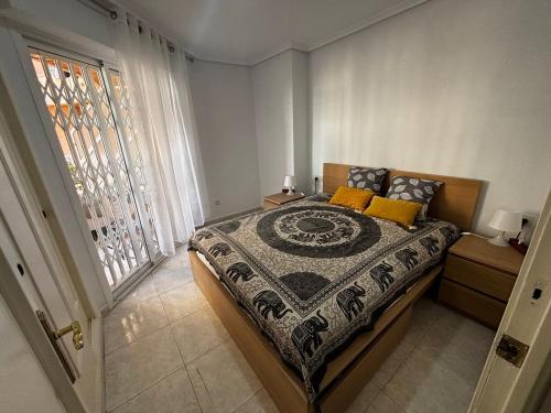 un dormitorio con una cama y una ventana en Calle Galeon, en Torrevieja