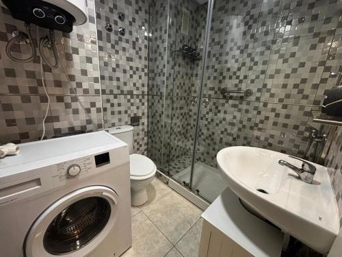 Un baño con lavadora y lavabo. en Calle Galeon, en Torrevieja