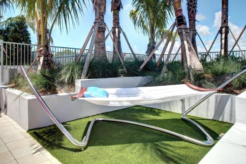 a hammock swing with palm trees in the background at Residence Inn by Marriott Miami Beach Surfside in Miami Beach