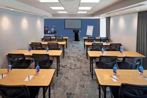 a classroom with tables and chairs and a screen at Residence Inn by Marriott Miami Beach Surfside in Miami Beach