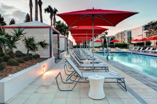 a row of tables with umbrellas next to a pool at Residence Inn by Marriott Miami Beach Surfside in Miami Beach
