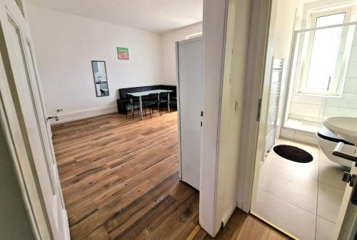a room with a hallway with a table and a room with a wooden floor at Worker's Apartment in Leverkusen L1-4 in Leverkusen