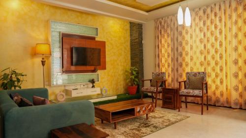 a living room with a couch and a tv at Luho 6 off Sarjapur Road in Bengaluru