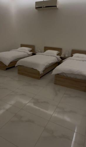 two beds sitting in a room with white walls at Hotel Apartment - 1 - LAvner Al hussma in Riyadh