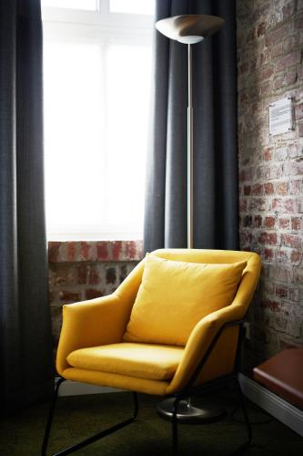 a yellow chair in a room with a window at Kochs Stadthotel in Olpe