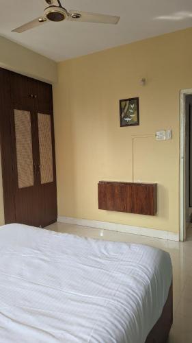 a bedroom with a bed and a dresser on the wall at Seneh Homes in Guwahati