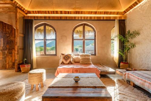Sunanda by 1810AD - A Boutique Organic Retreat في بوشكار: غرفة كبيرة بسريرين ونوافذ