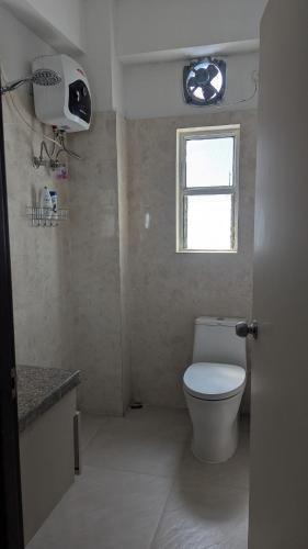 a bathroom with a toilet and a window at Seneh Homes in Guwahati