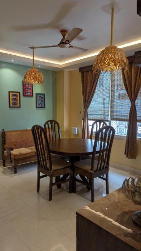 a dining room with a wooden table and chairs at Seneh Homes in Guwahati