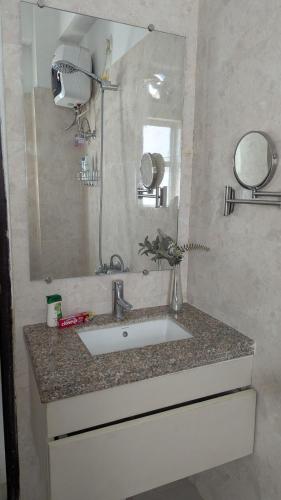 a bathroom with a sink and a mirror at Seneh Homes in Guwahati