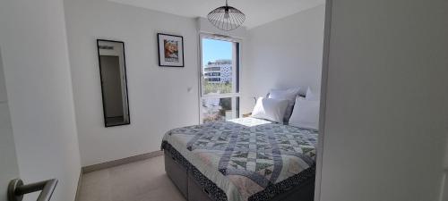 une chambre avec un lit et une fenêtre dans l'établissement Appartement neuf, climatisé et au calme à Fréjus Plage, à Fréjus
