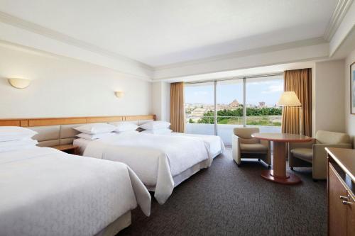 a hotel room with two beds and a table and a window at Sheraton Grande Tokyo Bay Hotel in Urayasu