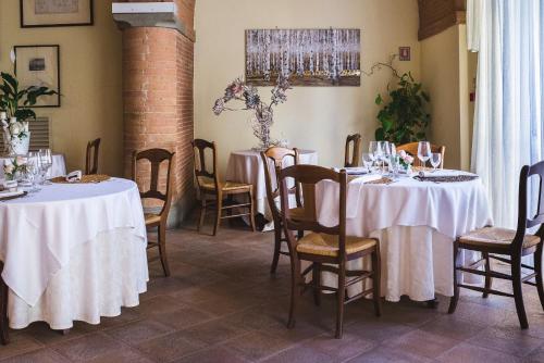 a dining room with two tables with white tablecloths at Villa Sonnino in San Miniato