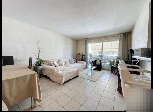 une chambre avec un lit et un canapé dans une pièce dans l'établissement Beau T2 à 200m de la mer et proches toutes commodités, à Antibes