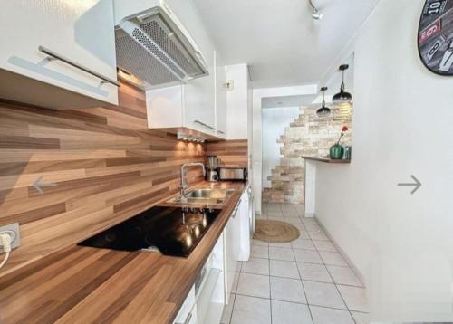 - une cuisine avec un évier et un comptoir en bois dans l'établissement Beau T2 à 200m de la mer et proches toutes commodités, à Antibes