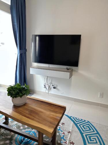 a living room with a flat screen tv on the wall at The Western Capital Apartment, Eric House in Ho Chi Minh City