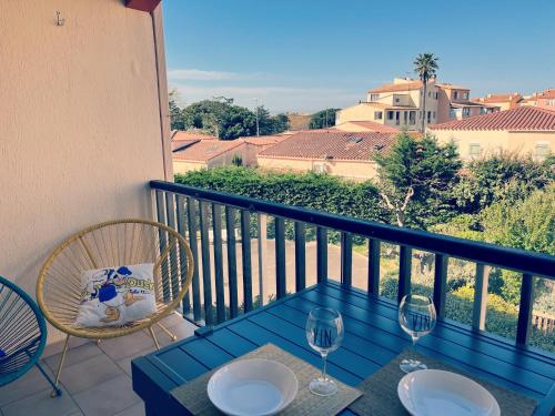 - un balcon avec une table et deux verres à vin dans l'établissement Bulle de Magie, au Cap d'Agde