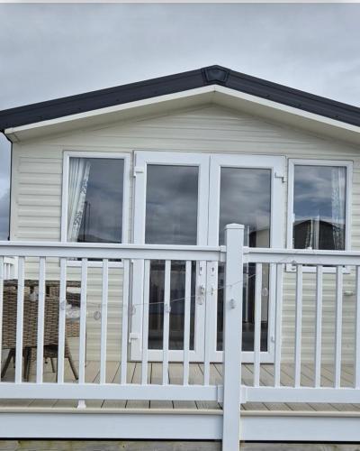 a white house with a white railing on a porch at Jan' Sea View Getaway in Heysham