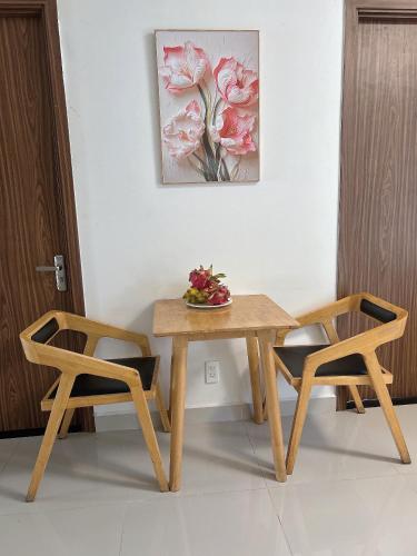a table and two chairs with a bowl of fruit on it at The Western Capital Apartment, Eric House in Ho Chi Minh City