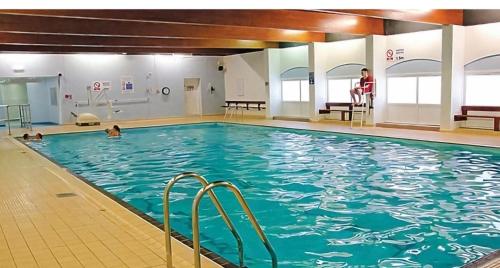 a swimming pool with a woman standing in the water at Jan' Sea View Getaway in Heysham