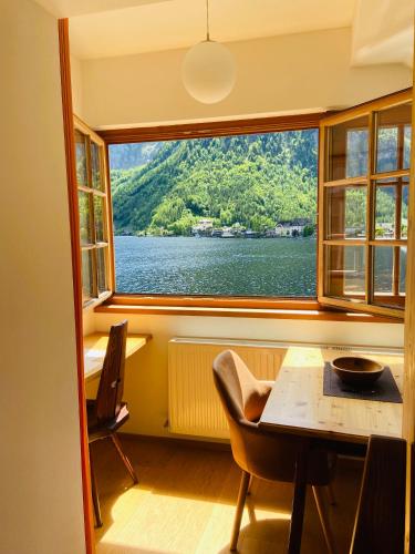 a room with a table and a large window at Pension Hallberg in Hallstatt