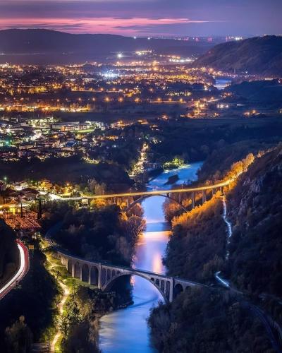 a view of a bridge over a river at night at Piuma apartment in Gorizia