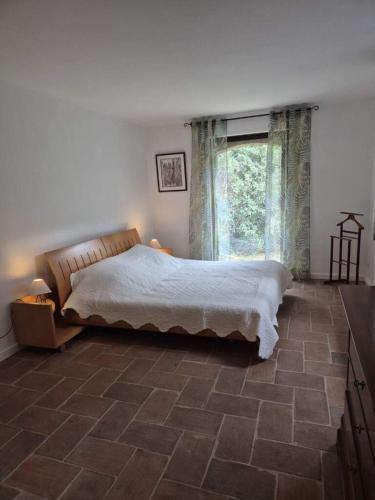 une chambre avec un lit et une grande fenêtre dans l'établissement Villa la source, à Salernes