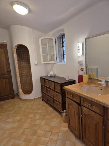une grande salle de bain avec un lavabo et un miroir dans l'établissement Villa la source, à Salernes