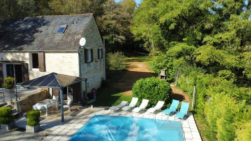 - une vue sur la piscine avec des chaises et une maison dans l'établissement Canterane, un coin de paradis à la campagne, à Salignac Eyvigues