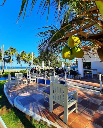 a group of white chairs sitting on a patio near the ocean at Hesperia Playa el Agua in El Agua