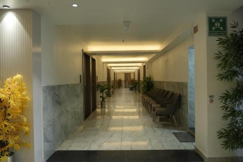 a hallway in a building with chairs and a hallway with a hallway at Hotel The Grand View,Gandhinagar in Gandhinagar