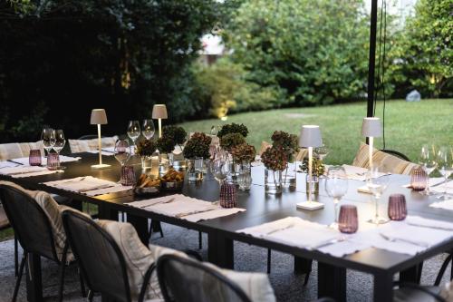a long table with wine glasses and flowers on it at Hotel Serenella in Baveno