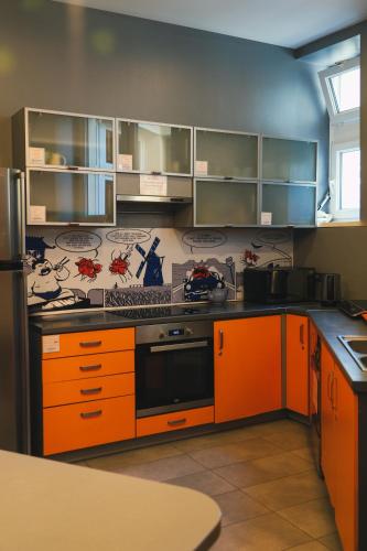 una cucina con mobili arancioni e una stufa di LazeMaze Hostel a Cracovia