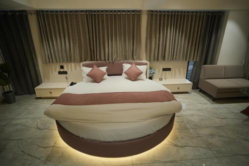 a bedroom with a large bed with pillows at Hotel The Grand View,Gandhinagar in Gandhinagar