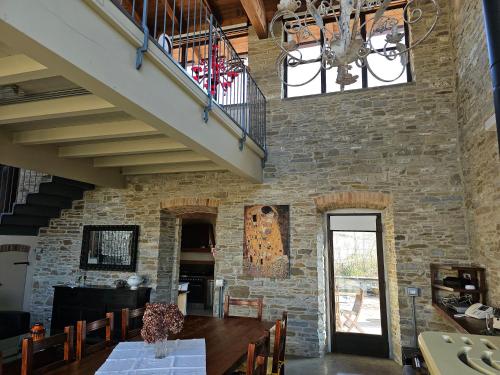 a dining room with a stone wall at Sogni nel Bosco in Varsi