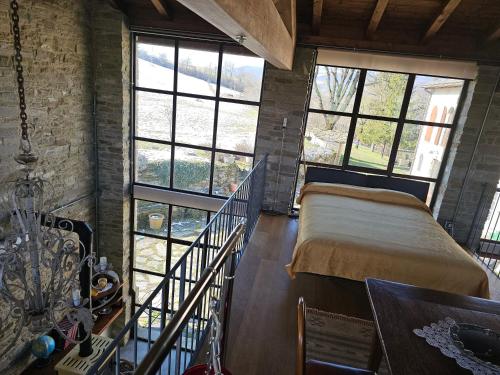 a bedroom with a bed in a room with windows at Sogni nel Bosco in Varsi