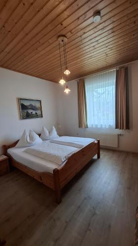 a bedroom with a large bed with a wooden ceiling at Ferienwohnungen Berger in Kötschach