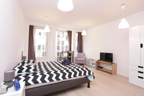 une chambre avec un lit noir et blanc et une télévision dans l'établissement Brussels center flat, à Bruxelles