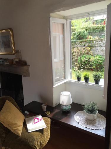 a room with a table with a window with potted plants at Appartamenti I Giardini Di Villa Melzi in Bellagio