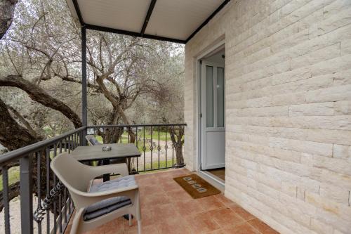 a patio with a table and chairs on a balcony at Apartments Oliva in Utjeha