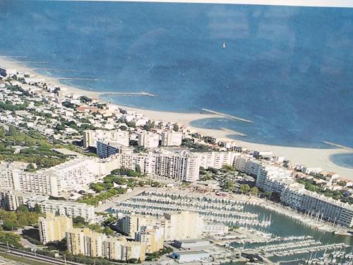 - une vue aérienne sur une ville avec une plage et des bâtiments dans l'établissement Appartement Spacieux 2 chambres, 4 personnes, Terrasse Vue Port , WIFI gratuit et Parking privé gratuit, lave linge, congélateur, situé près de la plage, commerces, marché et restaurants, à Carnon-Plage