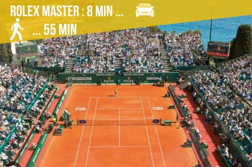 a tennis match on a tennis court with a large crowd at Appartement moderne climatisé Monaco vue Mer in Cap d'Ail