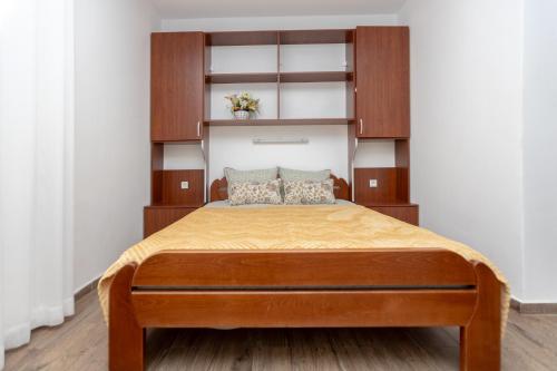 a bedroom with a bed with wooden cabinets at Apartments Oliva in Utjeha